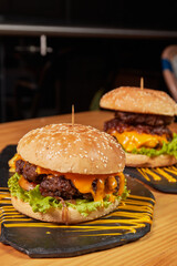 Delicious burger with double meat, caramelized onion, fresh vegetables and potatoes