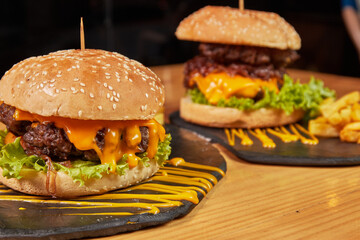 Delicious burger with double meat, caramelized onion, fresh vegetables and potatoes