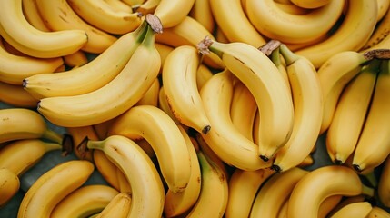  a pile of ripe bananas sitting on top of each other on top of a blue tablecloth covered tablecloth in front of a pile of yellow and green bananas. - obrazy, fototapety, plakaty