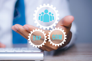 Businessman show CRM and ERP symbol to support business database analysis.