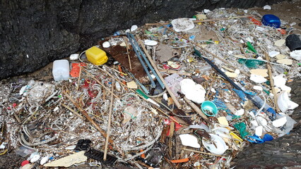 해안가에 떠밀려온 쓰레기 더미.
A pile of trash washed up on the shore.