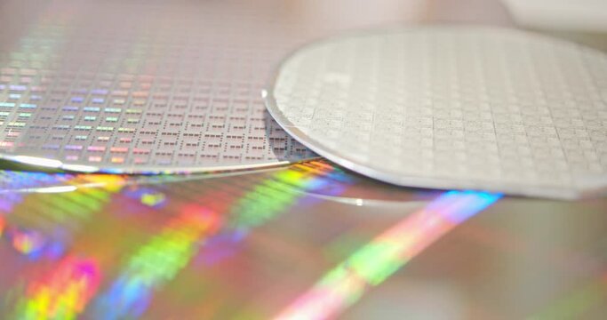 A close-up view of a silicon wafer's microprocessor circuit layout. The semiconductors or central processing unit CPU microchips are fabricated from a silicon wafer with patterned layers of materials.