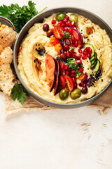 Hummus. Large bowl of homemade hummus garnished with chickpeas, vegetables and olive oil. Middle east food.