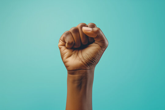 Raised clenched fist symbolizing female power and black women's equality on a teal background, suitable for Black History Month and Women's Day.