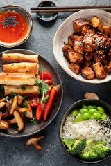 Homemade sesame Chicken served with white rice and vegetables. Asian food dishes.