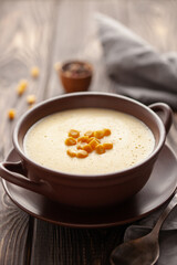 Delicious creamy corn soup in ceramic bowl on the table. Vegetarian food