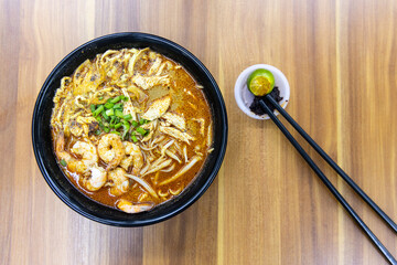 Top down view of no frills simple but delicious Sarawak laksa noodle soup served with shrinps in hawker stall