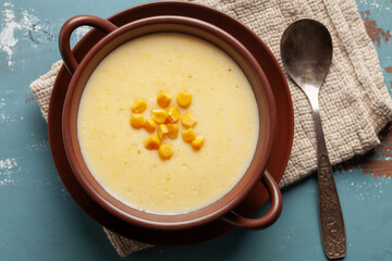 Delicious creamy corn soup in ceramic bowl on the table. Vegetarian food