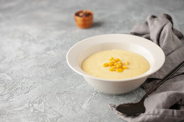 Delicious creamy corn soup in ceramic bowl on the table. Vegetarian food