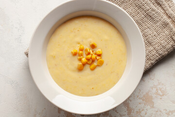 Delicious creamy corn soup in ceramic bowl on the table. Vegetarian food