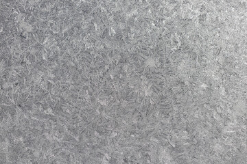 Full frame macro abstract texture background of an ice frosted glass window pane in a color shade of pearl white, with copy space
