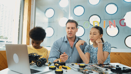 Caucasian student asking teacher about code and pointing at laptop screen. Professional instructor...