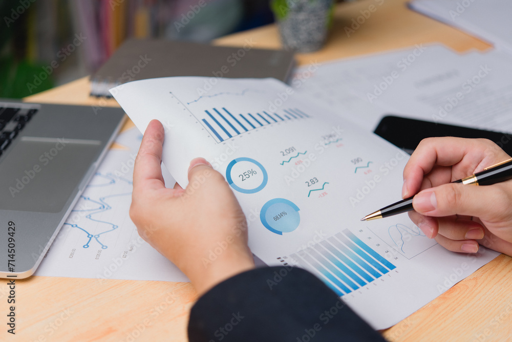 Aufkleber close-up of a professional hand reviewing business document data performance analytics and printing 