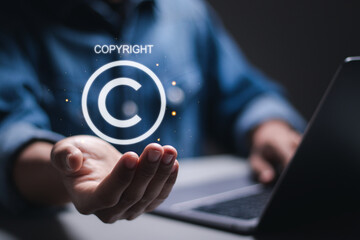 Copyright or patent concept. Person use laptop with virtual copyright symbol for author rights and patented intellectual property. - obrazy, fototapety, plakaty
