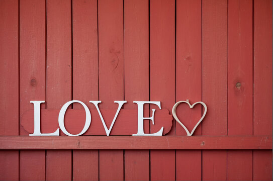 A red painted wood background with the word love and a heart