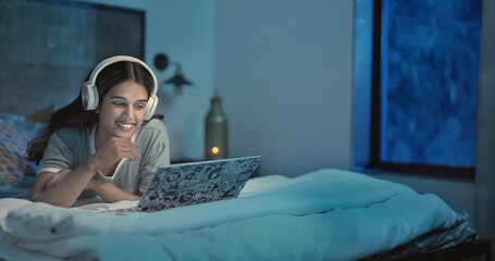Indian Asian Hindu happy gen z adult female girl use laptop make online video call talk gossip late...