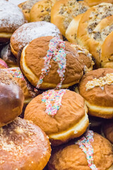 Fresh glazed donuts and other cookies on market stall or in grocery shop. Delicious dessert