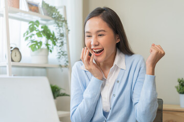 Excited with computer, happy celebrating success asian young woman, girl amazed looking good news at pc, laptop on desk at home office, get win online lottery, student winner celebrating achievement.