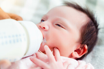 Baby boy drinking milk from milk bottle Adorable blue-eyed baby 1 month old drinks milk from a...
