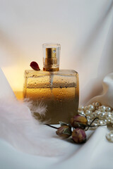 Blank perfume bottle with gold and marble cup in front of a brunch of cherry blossom. Photography in beige tones