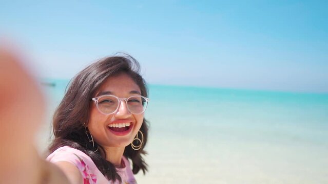 Selfie video of happy tourist Indian girl enjoying summer vacation at white sand beach of Agatti Island, Lakshadweep, India. Tourist at Lakshadweep Island during summer holidays. 