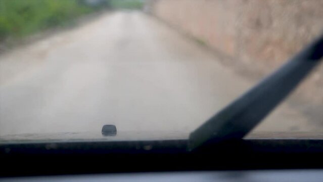  Slow motion, windshield wipers shoot water at the car window to clean it