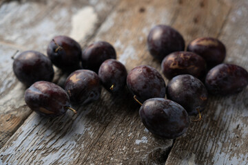 Ripe plums on an old wooden background, horizontal format