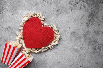 A banner for the film industry. A romantic movie date. A popcorn heart and retro striped cups on a...
