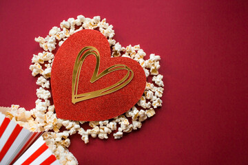 A banner for the film industry. A romantic movie date. A popcorn heart and retro striped cups on a red background. The film will premiere on Valentine's Day.
