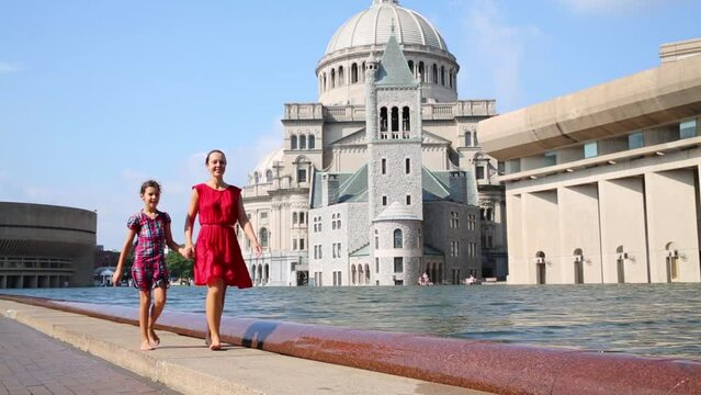 Woman with daughter walk near First Church of Christ, Scientist