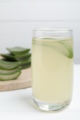Tasty aloe juice in glass on white table, closeup