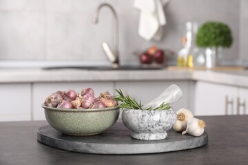 Fresh raw garlic and rosemary on grey table