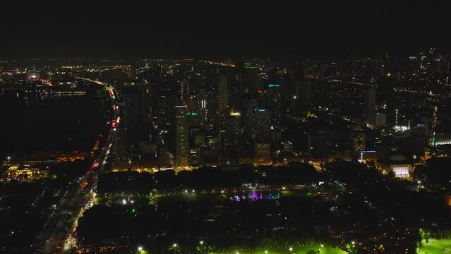 Aerial view of City of Manila with illuminated skyscrapers and seaport at night.