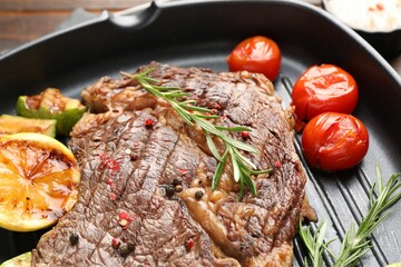 Delicious grilled beef steak and vegetables in frying pan, closeup