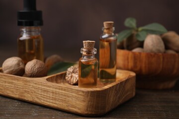 Nutmeg essential oil and nuts on wooden table