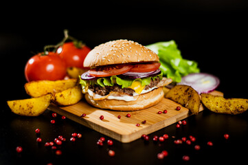 Hamburger with meat patty and cheese. bacon and fresh vegetables