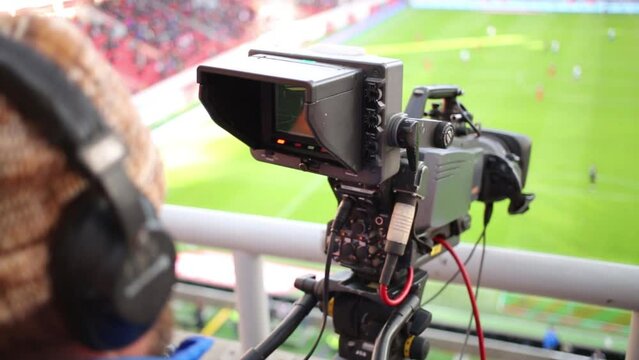 Cameraman shoots video reportage at stadium during game 