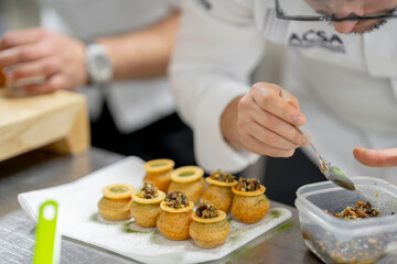Chef Preparing Gourmet Hors d'Oeuvres with Precision in a Professional Kitchen