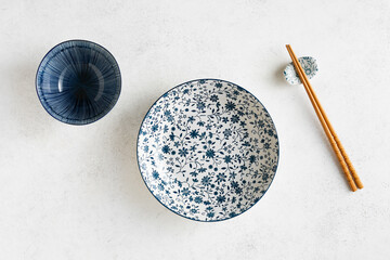 Empty dishes in asian style, deep plate, rice bowl, and chopsticks, top view.