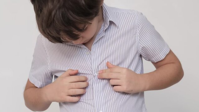 Young boy focused on buttoning shirt. skill that signifies growing independence, resonating with childhood development. head down in concentration. youth's journey to self-sufficiency.