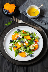 arugula persimmon cheese berries salad, top view
