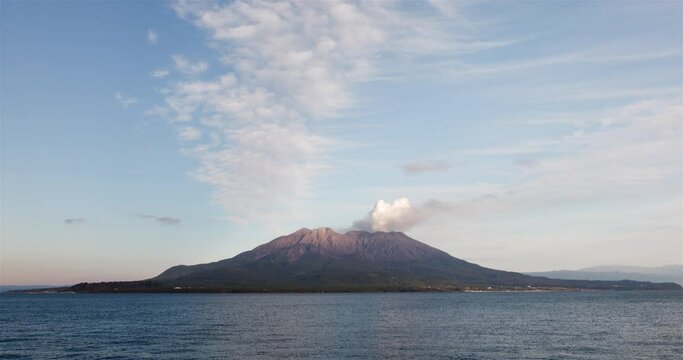 噴煙を上げる火山島がある海の風景。