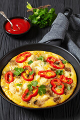 omelette with vegetables in a pan, top view