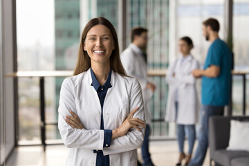Happy confident beautiful doctor woman looking at camera for professional portrait with arms...