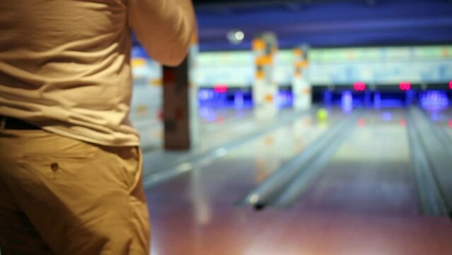 Players in bowling center throw balls towards targets 