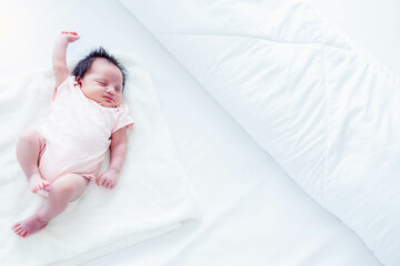 Obraz na płótnie Canvas Portrait adorable newborn baby happy dreaming stretching and stretch lazily on bed at home topview Little girl baby lying down and get good dream and good sleep on bed baby girl has good health