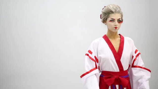 Woman in kimono with make up of Japanese geisha in studio