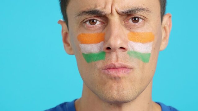 Serious man with a indian flag painted on the face