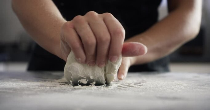 Person, hands and dough with flour on kitchen counter for baking, cooking or pizza process in apartment. Chef, bakery and pastry for recipe, handmade cake or bread with wheat or preparation in home