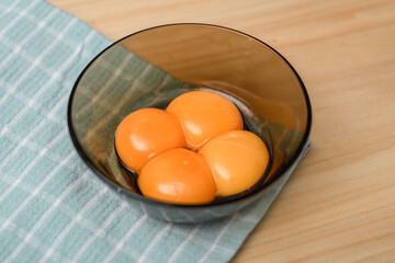 Surowe żółtka jaj kurzych w miseczce z bliska , intensywnie pomarańczowe 